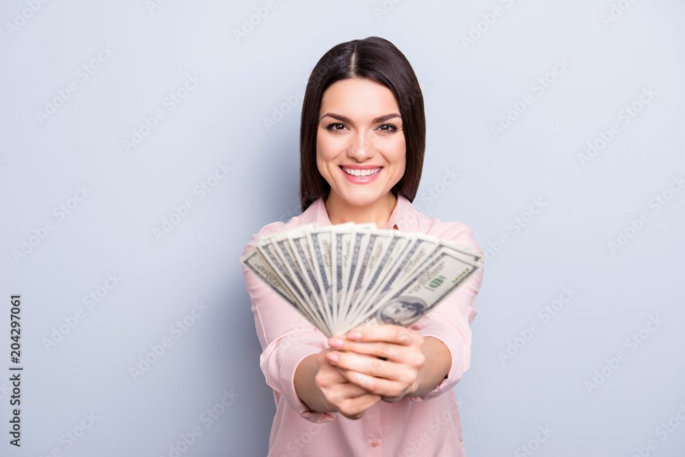 Portrait of trendy positive charming pretty woman giving proposing gesturing fan from dollars front to the camera isolated on grey background Portrait of trendy positive charming pretty woman giving proposing gesturing fan from dollars front to the camera isolated on grey background
