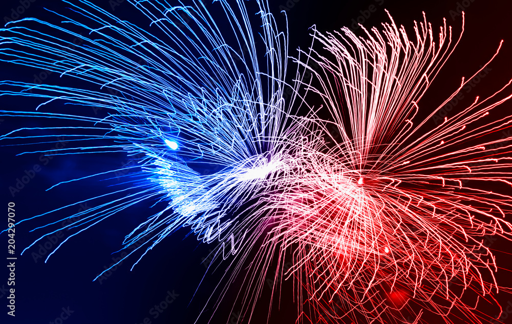 Fototapeta premium Dramatic red and blue fireworks at night sky background