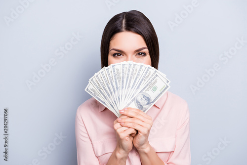 Portrait of pretty charming positive glad funny woman covering closing half face with fan from dollars looking out with eyes at camera isolated on grey background