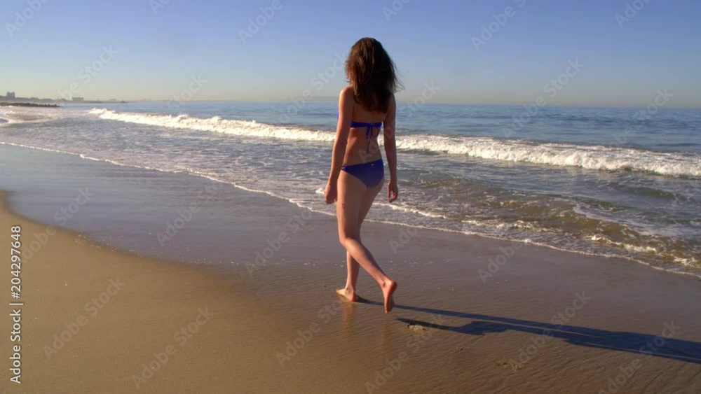 Attractive woman walking on the beach. Slow Motion shot. Attractive woman walking on the beach. Slow Motion shot.