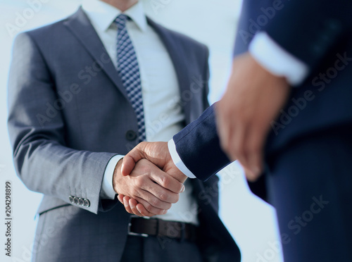 Friendly smiling businessmen handshaking. Business concept photo