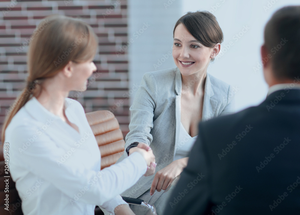 Fototapeta premium handshake of a Manager, and a client sitting behind a Desk