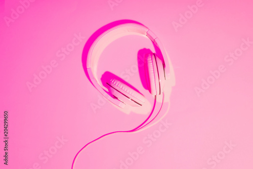 pink toned picture of headphones on pink background
