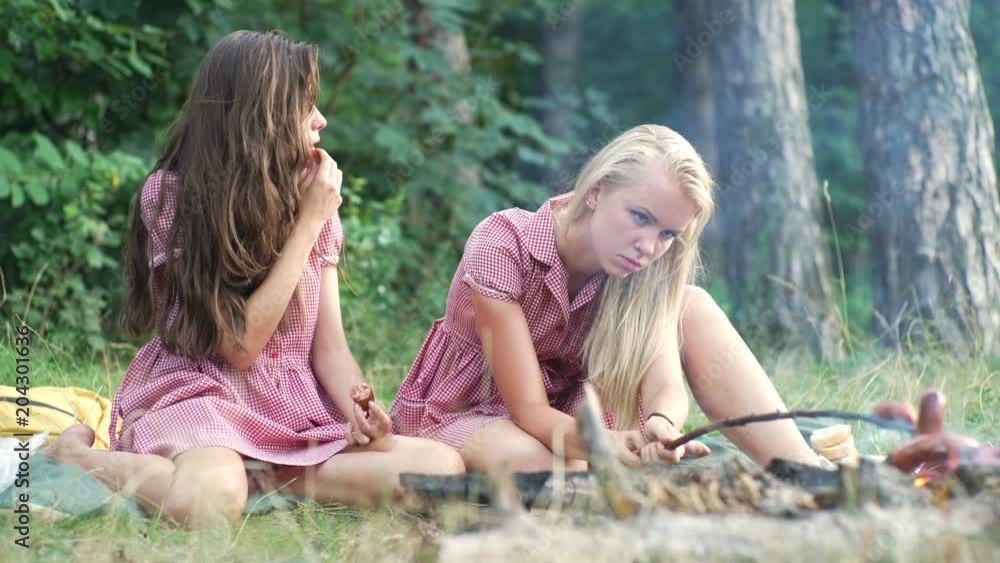 Group of friends having pic-nic in a park on a sunny day - People hanging out, having fun while grilling and relaxing. Group of friends relaxing the park on beautiful autumn day.