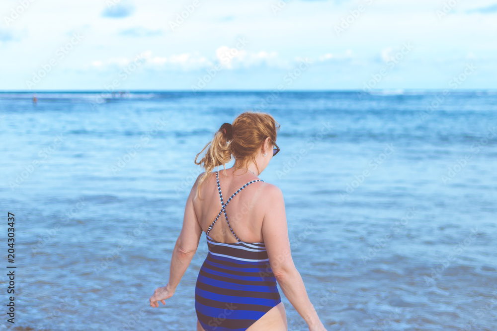 Senior woman on the beach. Travel vacation to Bali island.