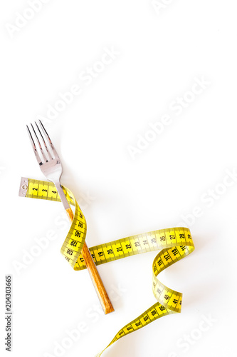 Diet  weight loss  slimming concept. Fork with wound measuring tape on white background top view space for text