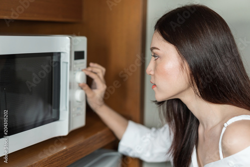 woman cooking with a microwave in kitchen room