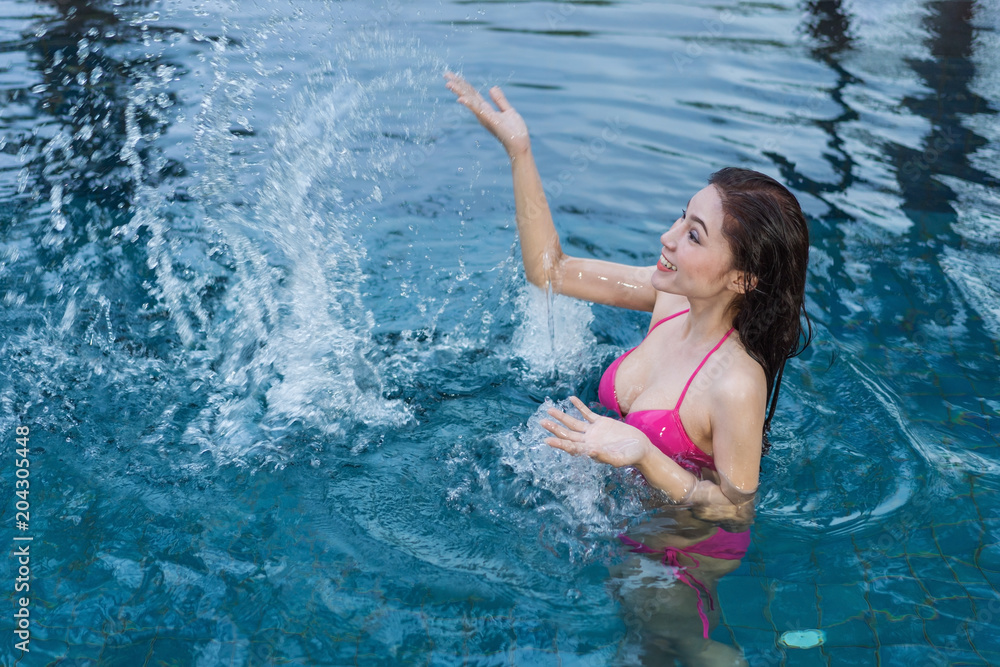 woman in pool and playing water splash