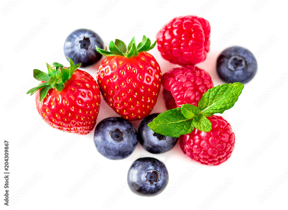 Sweet berries mix isolated on white background. Heap of Ripe raspberry, strawberry and blueberries, mint leaf. Macro, top view Sweet berries mix isolated on white background. Heap of Ripe raspberry, strawberry and blueberries, mint leaf. Macro, top view
