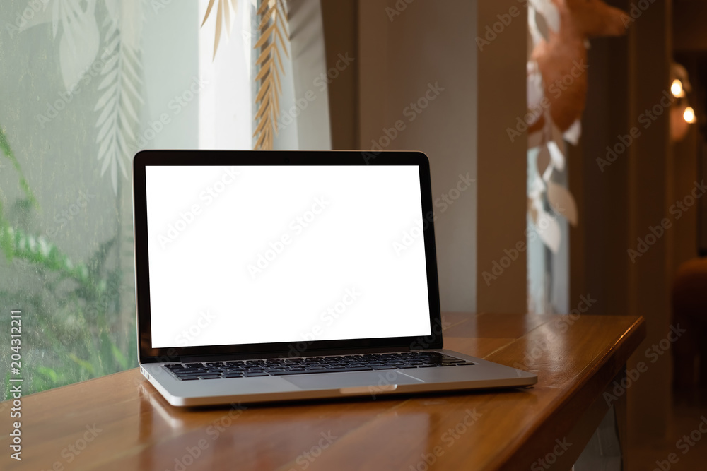 Fototapeta premium Laptop computer with blank screen on wooden desk in coffee shop.