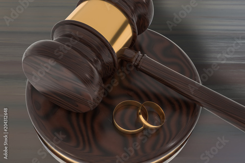 Divorce concept with wooden gavel and gold wedding rings