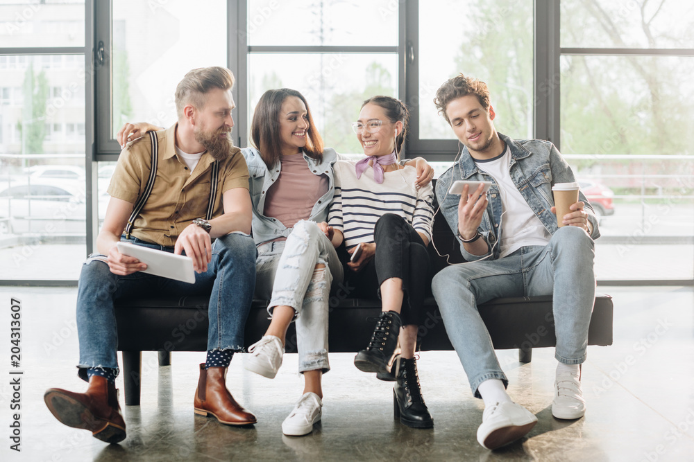 Smiling business colleagues men and women relaxing in modern office Smiling business colleagues men and women relaxing in modern office