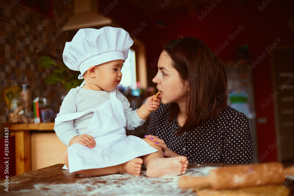The mother with son eatting cookies in the kitchen The mother with son eatting cookies in the kitchen