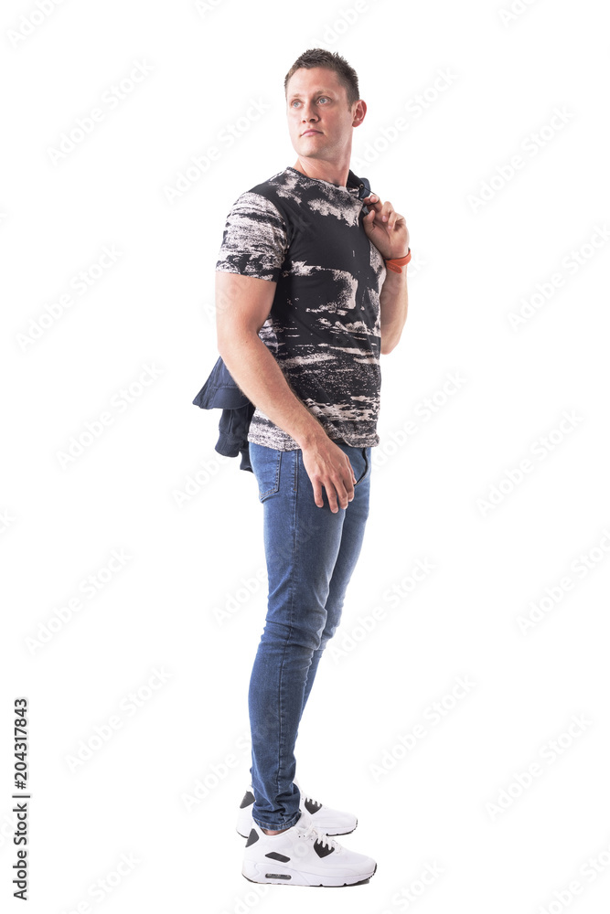 Side view of young adult confident man carrying jacket over shoulder looking back. Full body isolated on white background. Side view of young adult confident man carrying jacket over shoulder looking back. Full body isolated on white background.