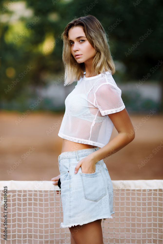Sport model posing on a tennis court. Sexy tennis girl Sport model posing on a tennis court. Sexy tennis girl