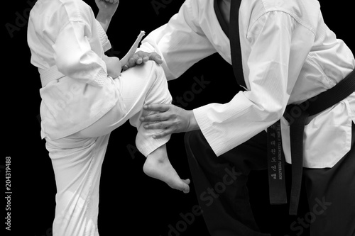 Man Teaching Taekwondo Fighter Kid Balance Stand for Flight on black background