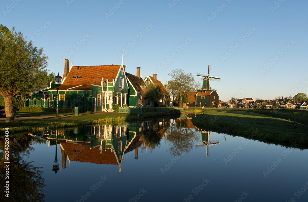 Water reflections in a pond in Zaanse Schans at sunrise, The Netherlands