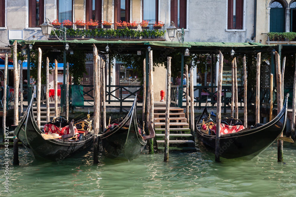The facade of the building with a pier and a boat in Venice.