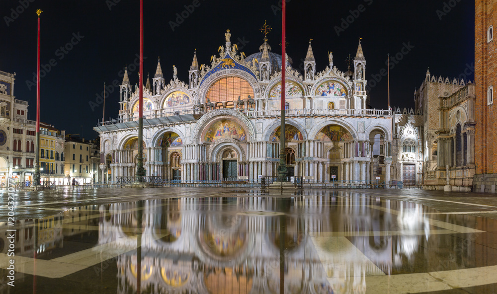 Basilica in San Marco square in Venice with reflection at night during the high tide, or aqua alta, that flooded the square with sea water