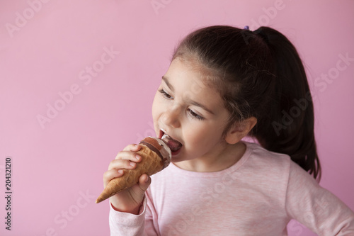 happy little girl with ice cream on a pastel background