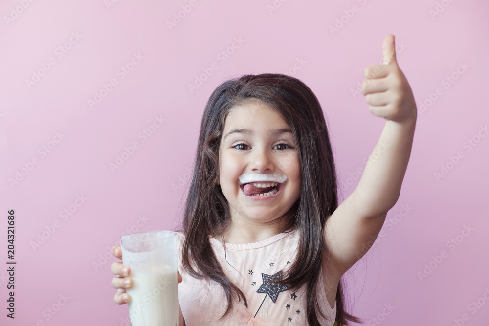 Happy child girl drinking yogurt. Whiskers from yogurt