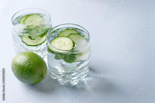 Detox water infused with sliced cucumber and springs of mint, copy space
