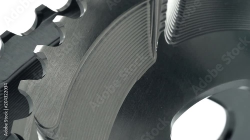 Black oval bicycle chainring gear rotating at white background, strong close up with visible details of structure photo