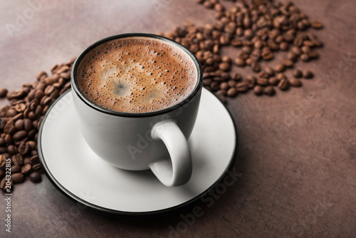 Coffee in a white mug with roasted beans