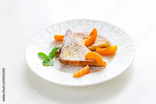 French toasts with fresh cut apricot, mint and icing powder. Healthy classic breakfast concept. Isolated. White background.