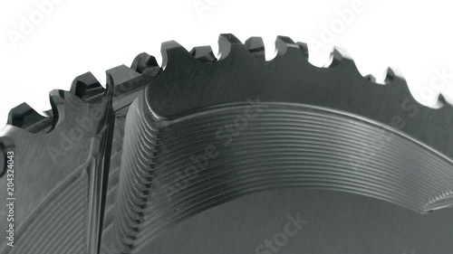 Black oval bicycle chainring gear rotating at white background, strong close up with visible details of structure photo