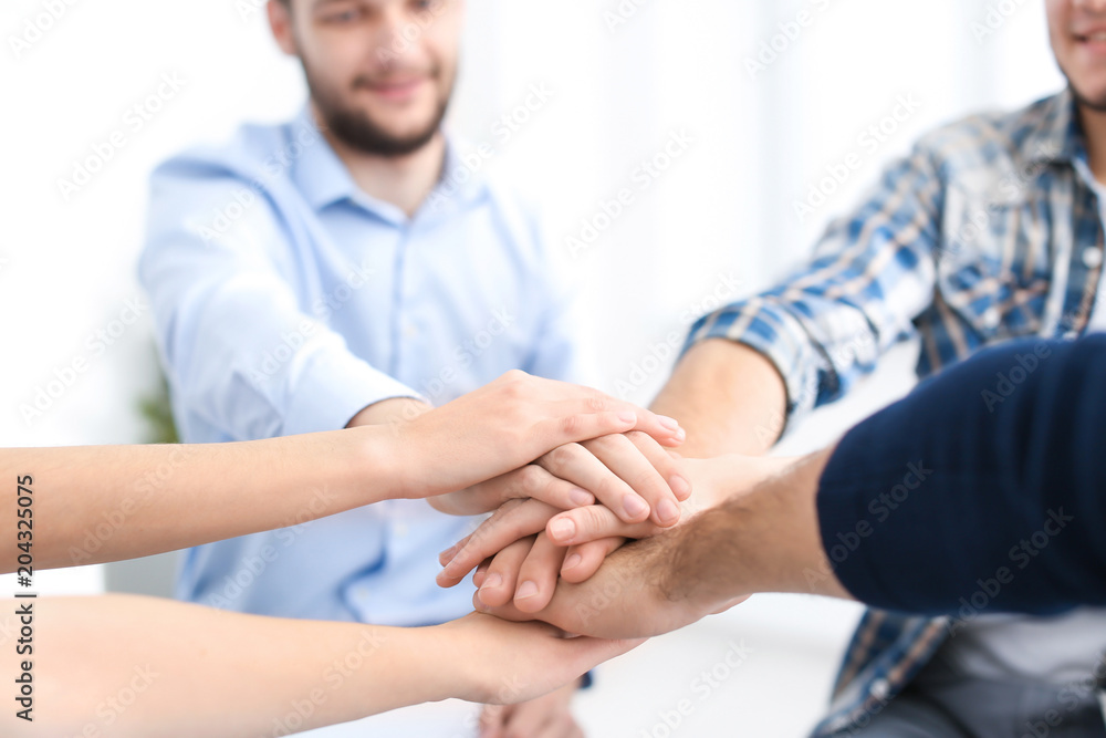 Obraz premium People putting their hands together at group therapy session