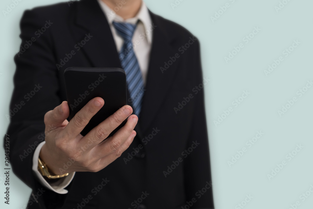 Businessmen in suit holding mobile phone on blue background. Businessmen in suit holding mobile phone on blue background.