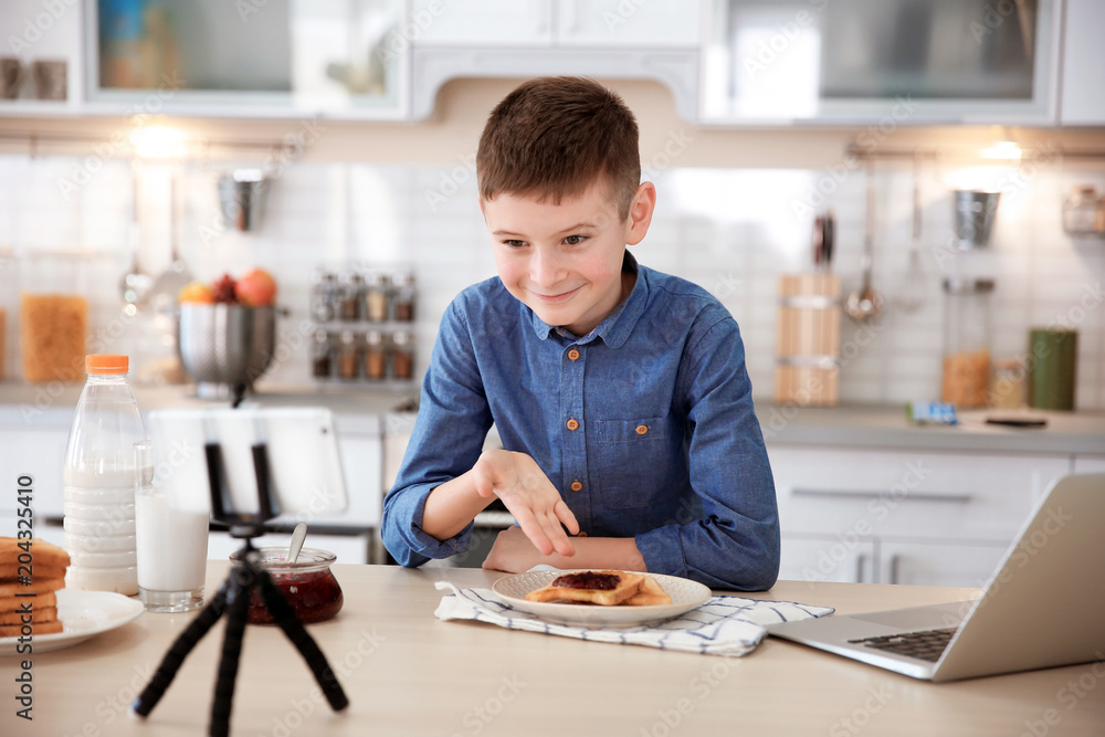 Cute little blogger with food recording video on kitchen Cute little blogger with food recording video on kitchen