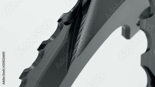 Black oval bicycle chainring gear rotating at white background, strong close up with visible details of structure photo