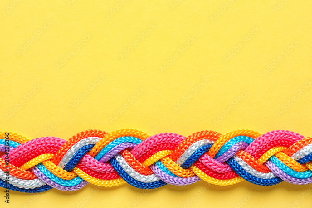 Braided ropes on color background, top view. Unity concept