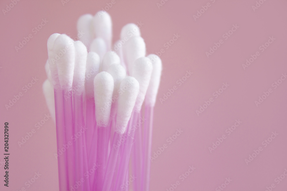 Close up of cotton buds on pink background. Cosmetic concept with copy space. Medicine and personal hygiene. Close up of cotton buds on pink background. Cosmetic concept with copy space. Medicine and personal hygiene.