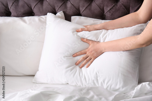 Young woman making bed, closeup