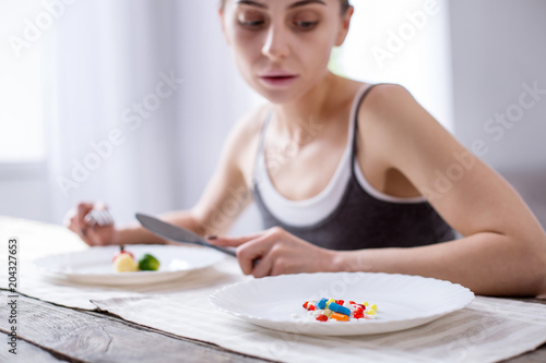 Unhealthy medicine. Selective focus of a plate with a pile of pills on it © zinkevych