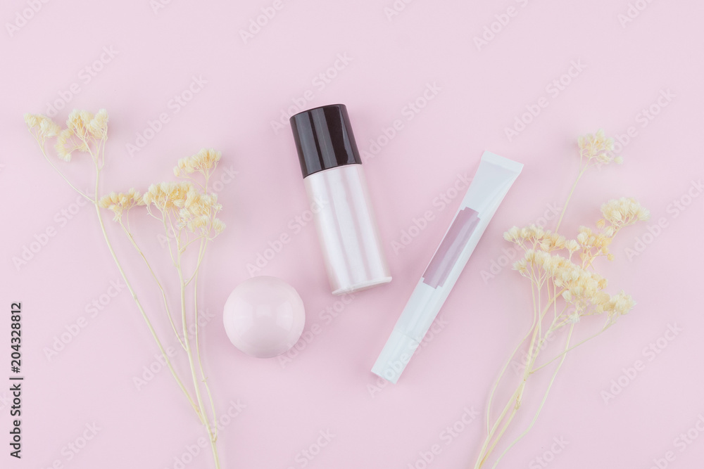 Skincare decorate with white dried flowers on pastel pink background Skincare decorate with white dried flowers on pastel pink background