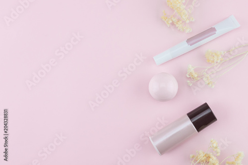 Skincare decorate with white dried flowers on pastel pink background with copy space
