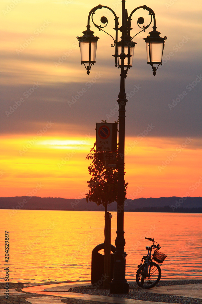 Lazise, tramonto sul lago di Garda con bicicletta Lazise, tramonto sul lago di Garda con bicicletta