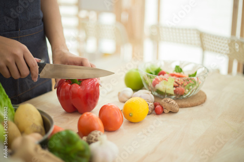 Young Woman Cooking Healthy Food and Vegetable Salad in the kitchen at home. Healthy Lifestyle.