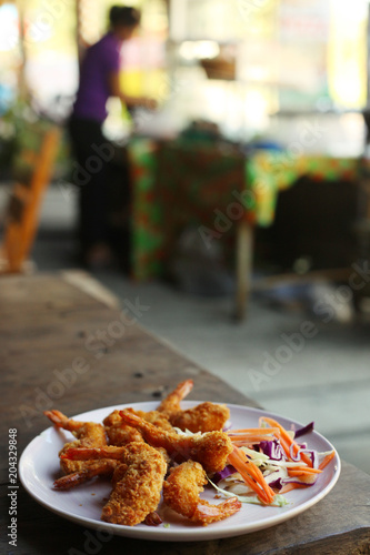 deep fried prawn in breading close up photo on the wooden table