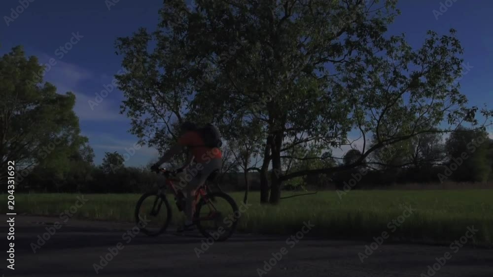 A young man is actively spending time on his bike at sunset. A bike ride in the sunset A young man is actively spending time on his bike at sunset. A bike ride in the sunset