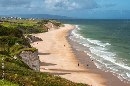 Panoramic view of people walking on Whiterocks Beach Portrush, Northern Ireland photo