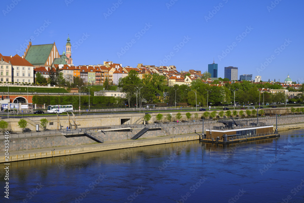 Obraz premium Warsaw, Poland - Panoramic view of historic quarter of Warsaw with Royal Castle and old town tenements seen from the Vistula river side