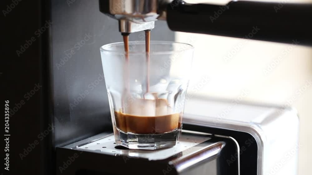 Coffee machine pouring espresso coffee in a glass