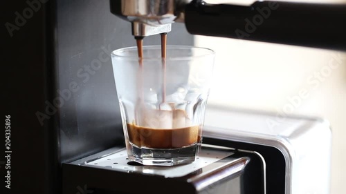 Coffee machine pouring espresso coffee in a glass