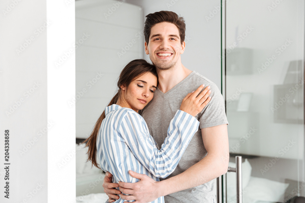 Smiling young couple embracing while standing Smiling young couple embracing while standing