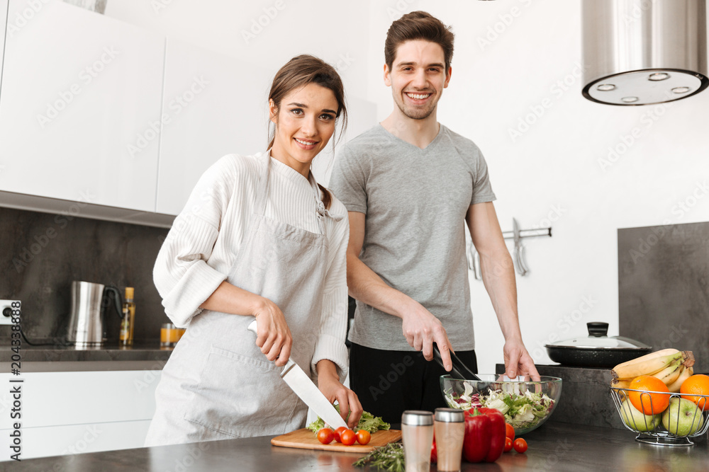 Portrait of a pretty young couple cooking together Portrait of a pretty young couple cooking together